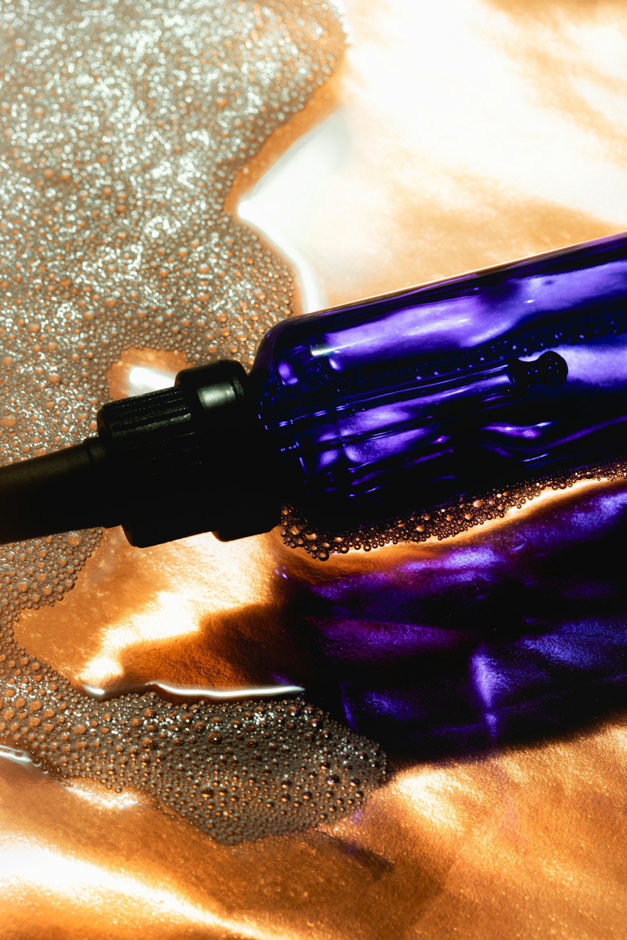 liquid cleansing product in purple dropper bottle
