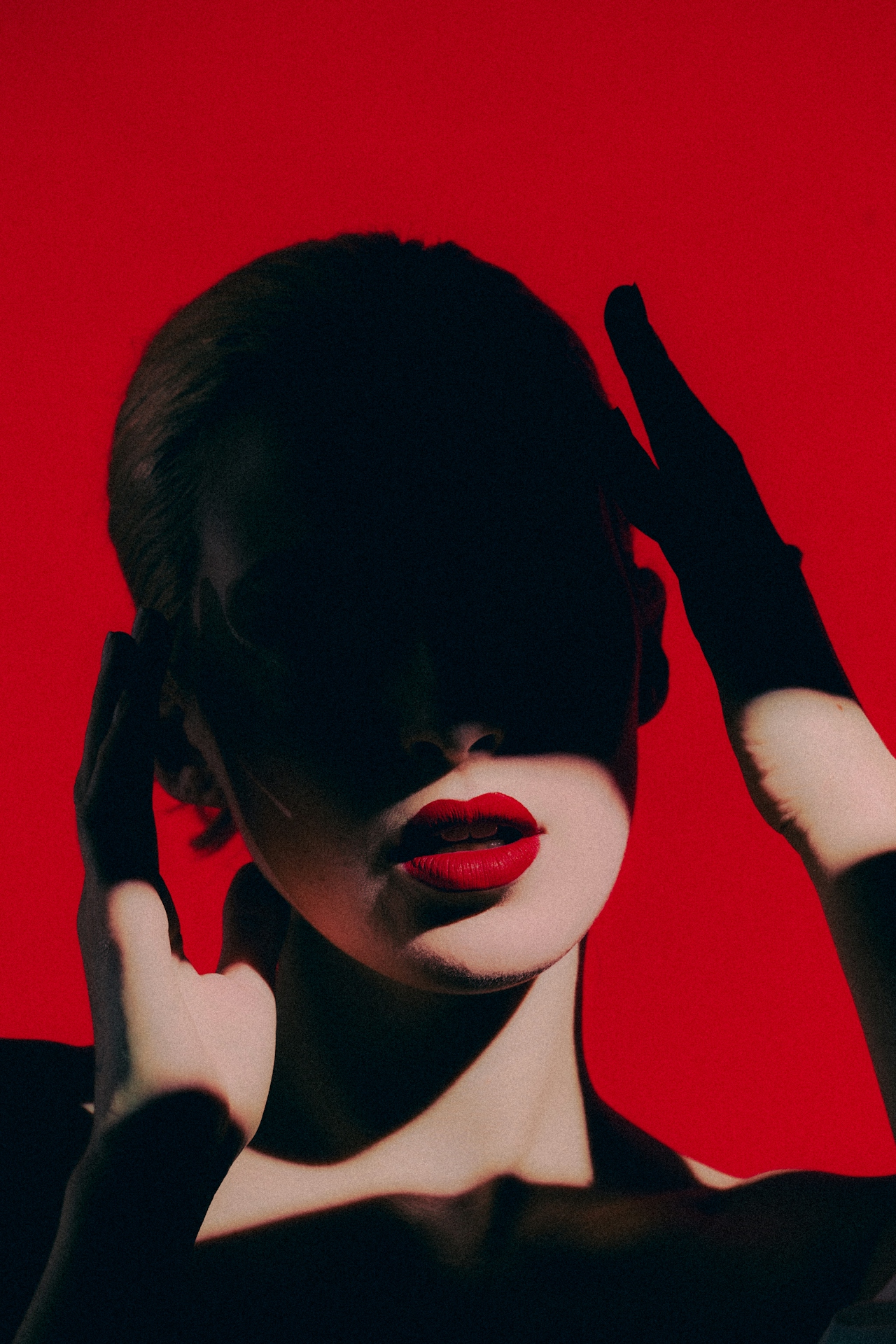 red background with woman in shadows with red lipstick model