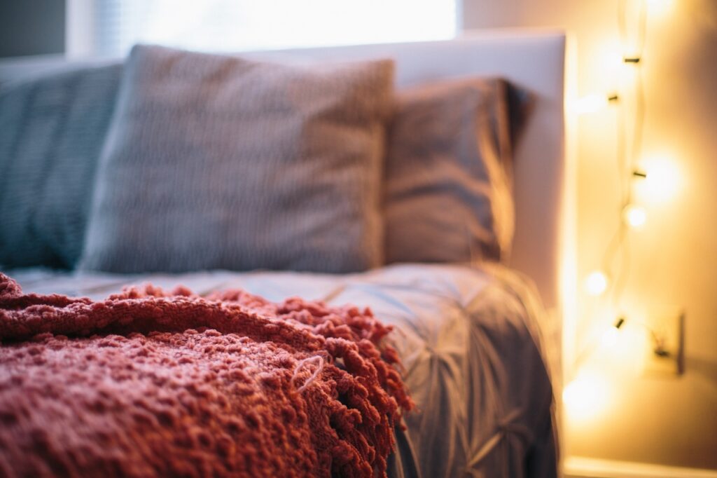 Bed with accent lights and cozy blanket